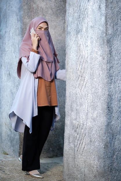 Foto seção média de uma mulher de pé contra uma parede de concreto