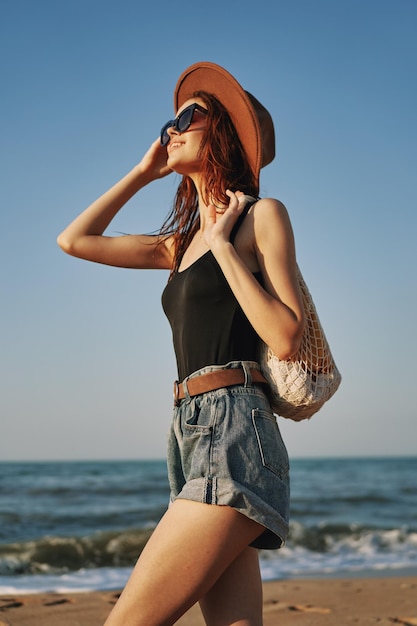 Seção média de uma mulher de pé na praia contra o céu