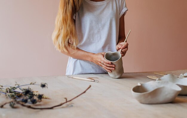 Foto seção média de uma mulher esculpindo sobre uma panela na mesa