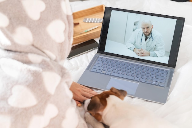 Foto seção média de uma mulher falando com um médico em uma chamada de vídeo