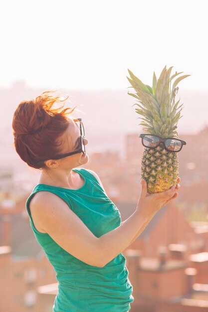 Foto seção média de uma mulher segurando frutas enquanto está de pé ao ar livre