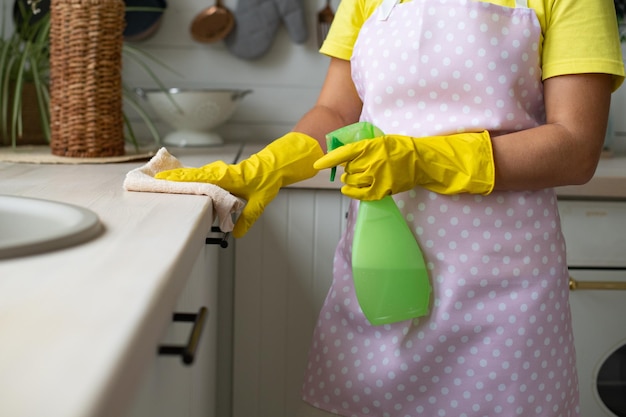 Seção média de uma mulher segurando um guarda-chuva em casa