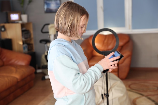 Seção média de uma mulher segurando um telefone móvel em casa