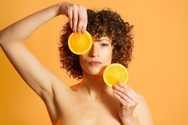 Seção média de uma mulher segurando uma maçã contra um fundo amarelo