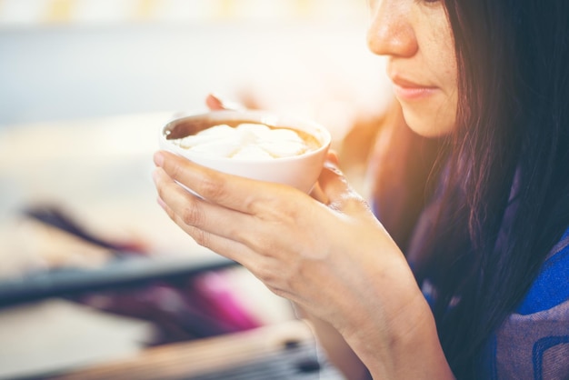 Seção média de uma mulher tomando café em um café