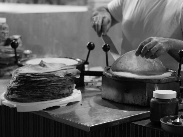 Foto seção média de uma pessoa preparando comida em uma barraca de mercado