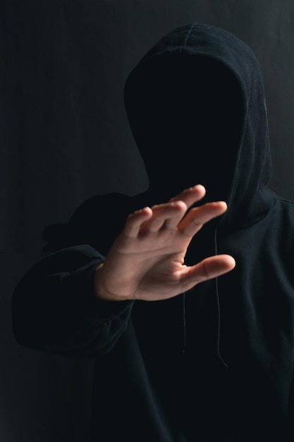 Seção média de uma pessoa segurando um cigarro contra um fundo preto