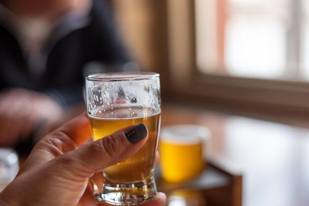 Seção média de uma pessoa segurando um copo de cerveja