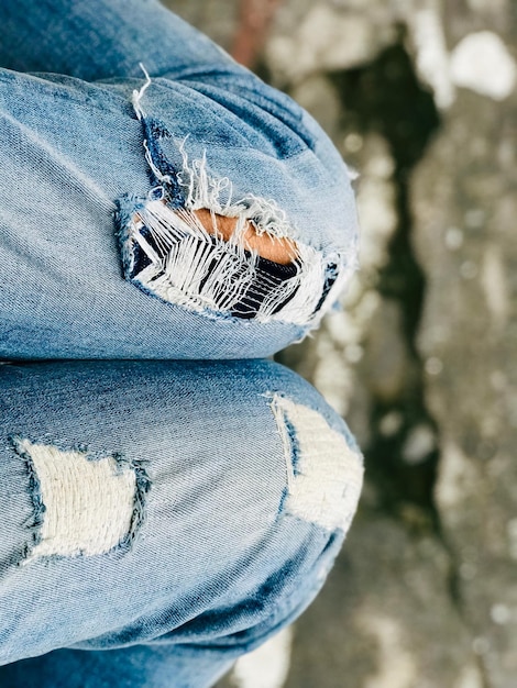 Foto seção média de uma pessoa vestindo jeans rasgados