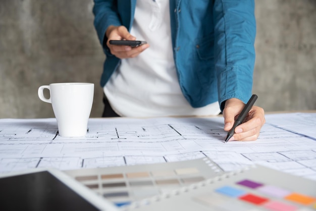 Seção média do arquiteto trabalhando sobre o plano com amostras de cores na mesa