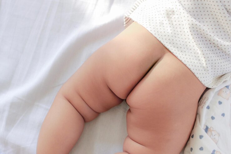 Foto seção média do bebê deitado na cama em casa