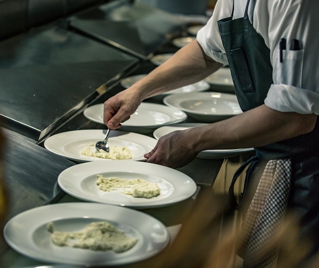 Seção média do chef servindo comida em prato