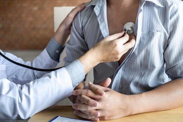 Foto seção média do médico analisando o paciente com estetoscópio