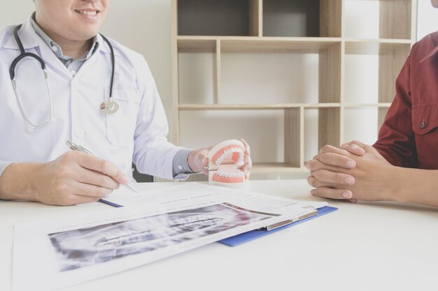 Seção média do médico mostrando dentaduras dentárias ao paciente