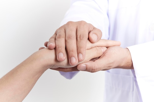 Seção média do médico segurando a mão do paciente contra um fundo cinzento