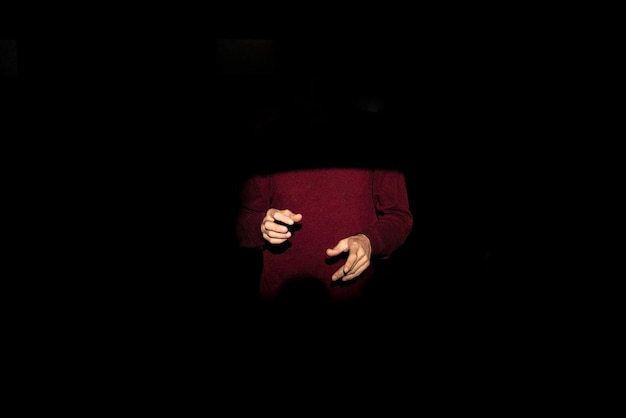 Seção média iluminada de um homem na câmara escura