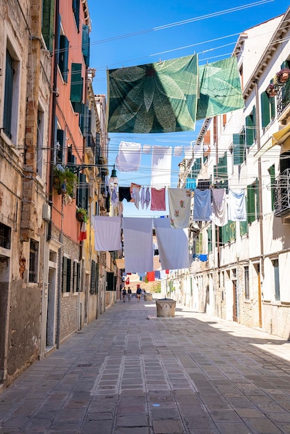 Secar la ropa mojada en el tendedero sobre el callejón entre edificios residenciales