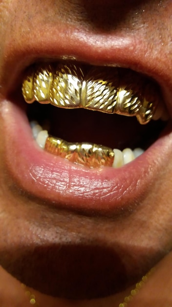 Foto secção do meio de um homem com dente de ouro