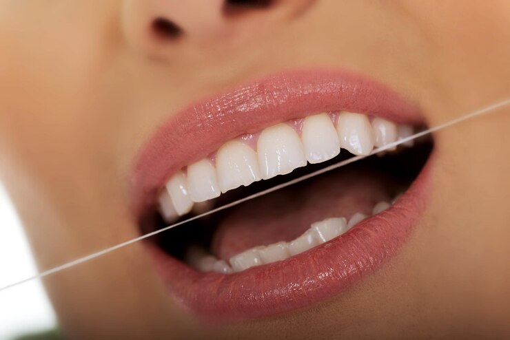 Foto secção média de uma mulher usando fio dental em close-up