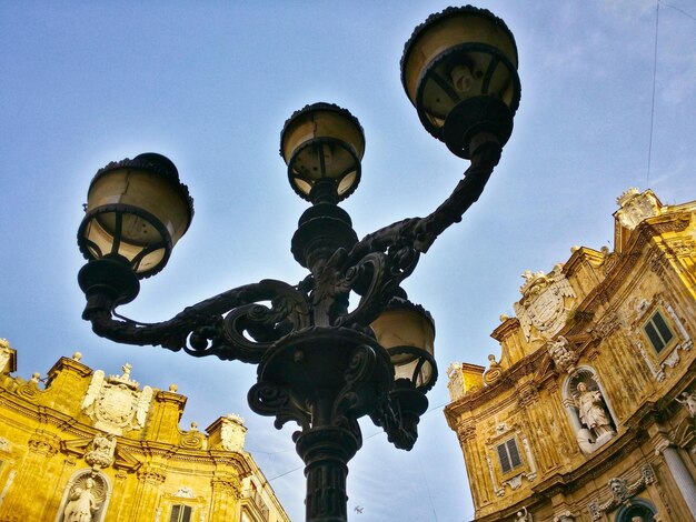 Sección alta del poste de luz contra las estructuras construidas