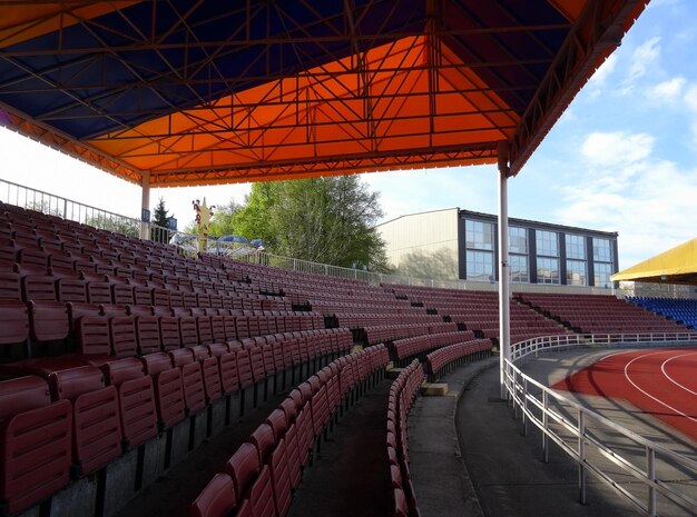 Sección de asientos de plástico en la tribuna del estadio deportivo