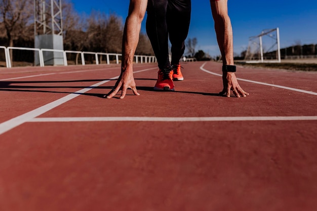 Foto sección baja del atleta haciendo ejercicio en la pista deportiva