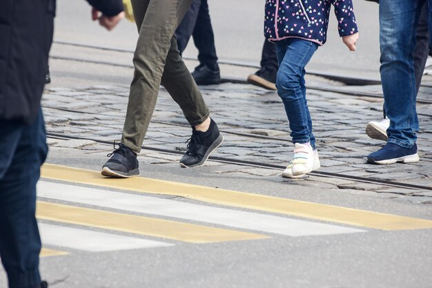 Sección baja de la gente caminando por la carretera