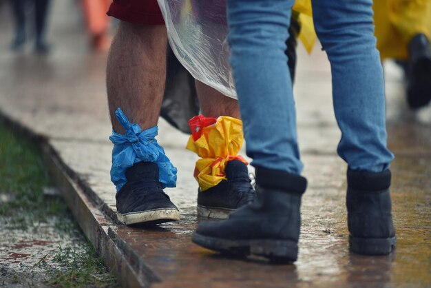 Foto la sección baja del hombre atado a una bolsa de polietileno en la pierna mientras estaba de pie en la calle