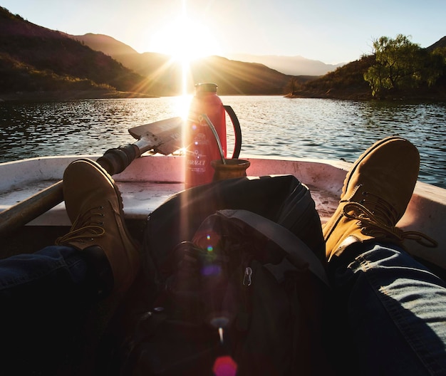 Foto sección baja de un hombre en un barco navegando por el río durante un día soleado