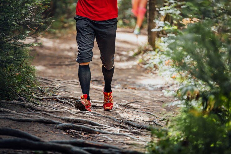 Foto sección baja de un hombre caminando sobre una roca en el bosque