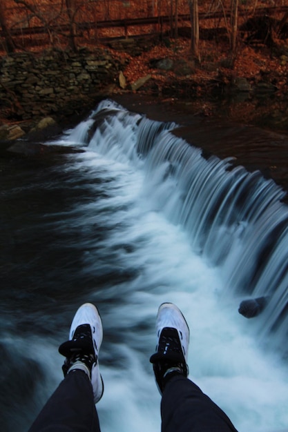 Foto sección baja del hombre por la cascada