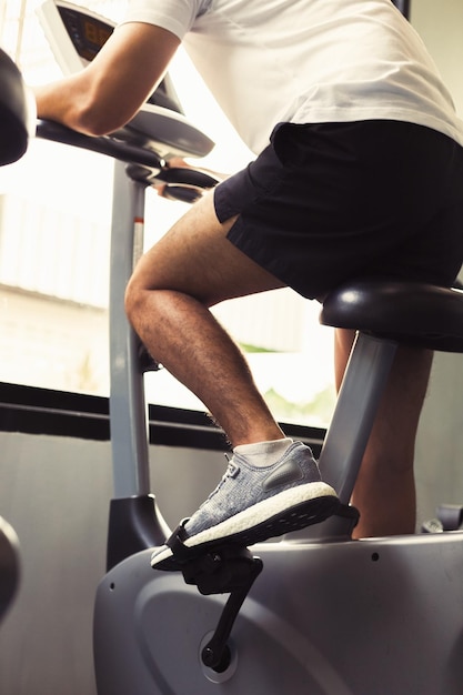 Sección baja de un hombre haciendo ejercicio con equipos en el gimnasio