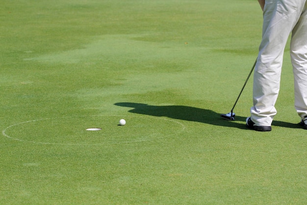 Sección baja de un hombre jugando al golf en el campo