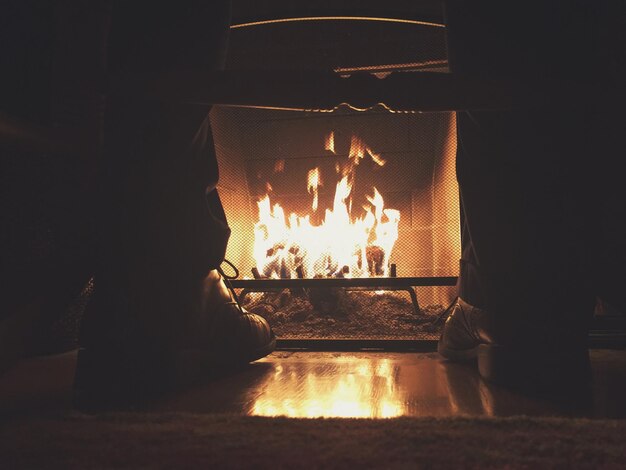 Sección baja del hombre junto a la chimenea en el hogar