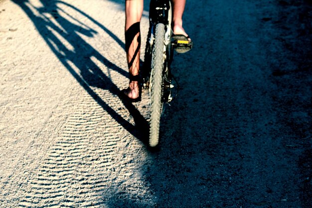 Foto sección baja de un hombre montando una bicicleta en la carretera
