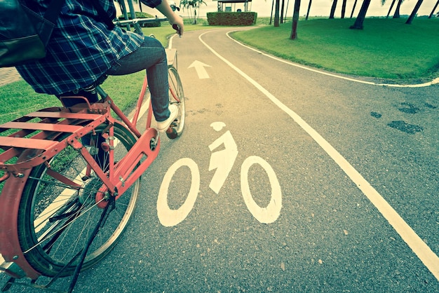 Foto sección baja de un hombre montando una bicicleta en la carretera