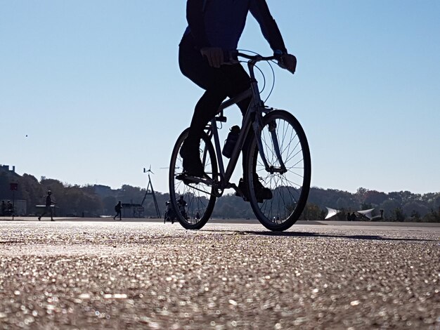 Foto sección baja de un hombre montando una bicicleta en la carretera