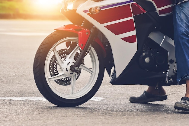 Foto sección baja de un hombre montando una motocicleta en la carretera