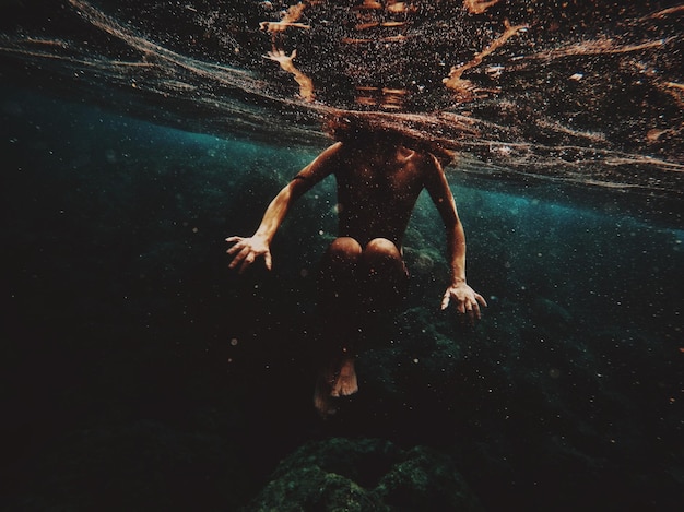 Foto sección baja de un hombre nadando en el mar