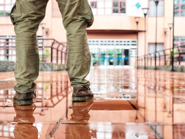 Sección baja del hombre parado junto al agua