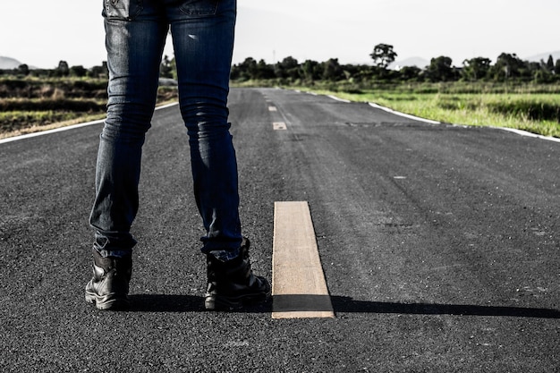 Foto sección baja de un hombre de pie en la carretera