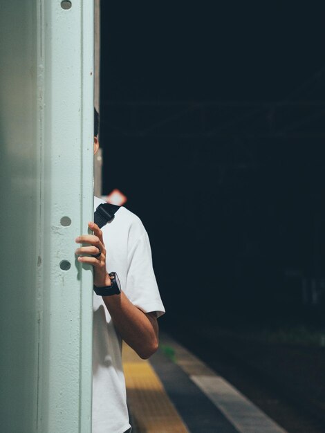 Foto sección baja de un hombre de pie contra la pared