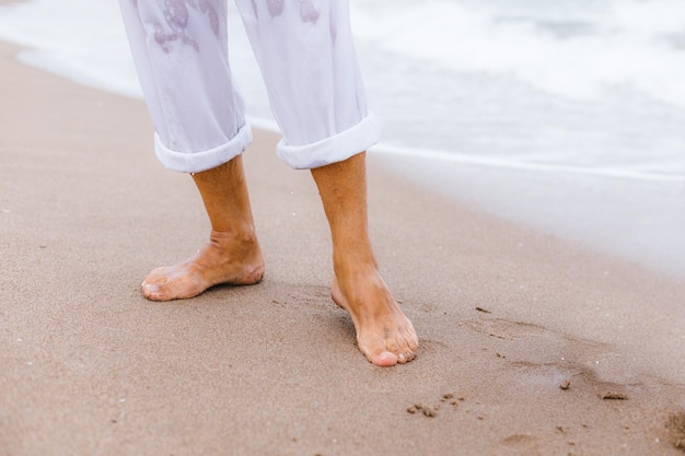 Sección baja de un hombre de pie en la playa