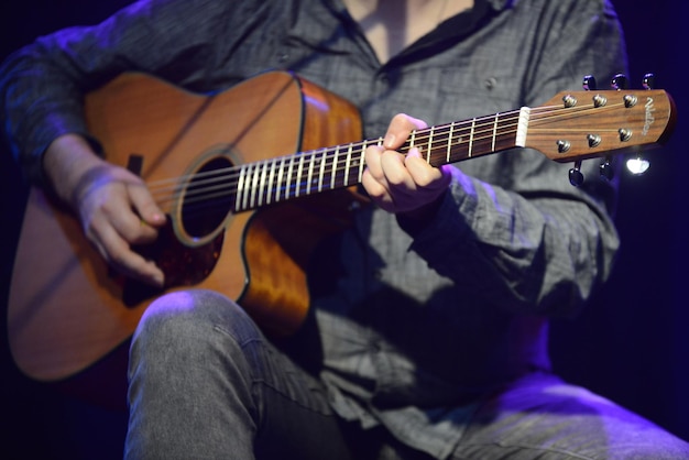 Sección baja del hombre tocando la guitarra