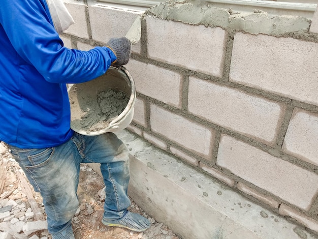 Foto sección baja de hombre trabajando en la pared.