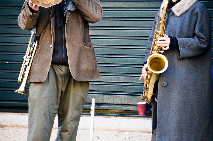 Foto sección baja de hombres de pie en la ciudad haciendo música