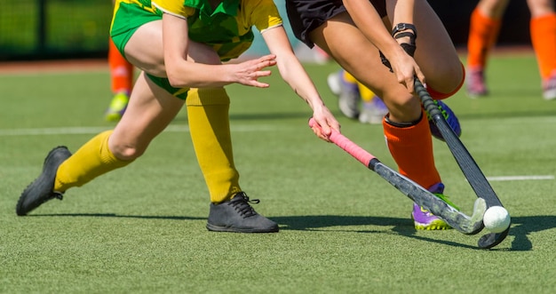 Sección baja de jugadoras jugando hockey en el campo