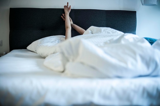 Sección baja de la mujer acostada en la cama en casa.