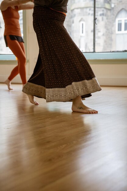 Foto sección baja de una mujer bailando en el suelo de madera dura