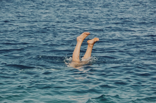 Sección baja de una mujer buceando en el mar